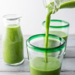 pouring kale smoothie into a glass