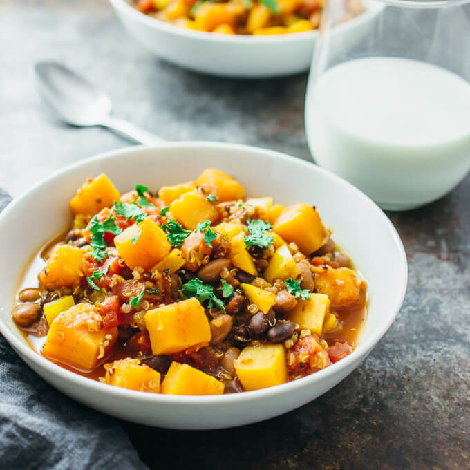 butternut squash chili served in bowl with glass of milk