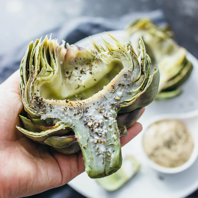 holding an artichoke in a hand