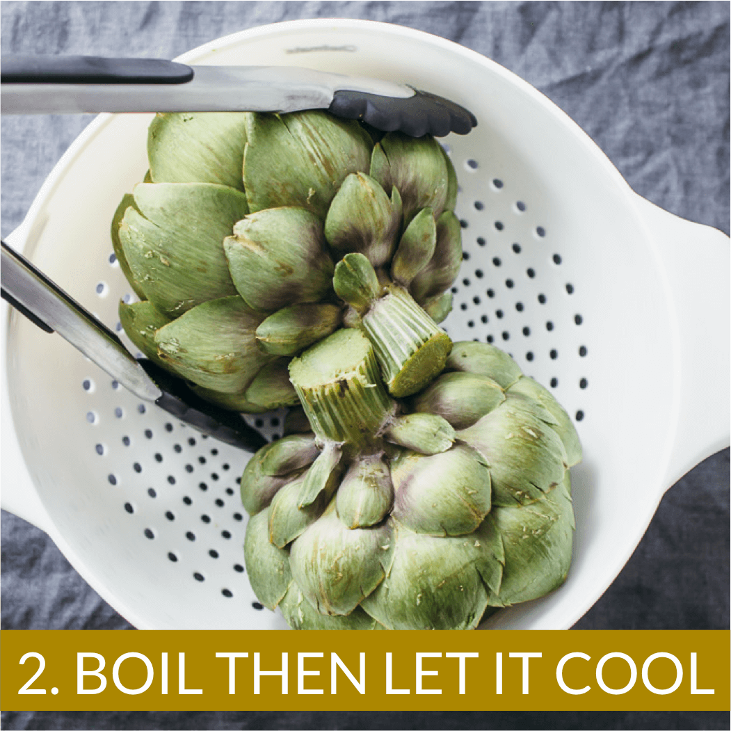boiled artichokes cooling in a colander