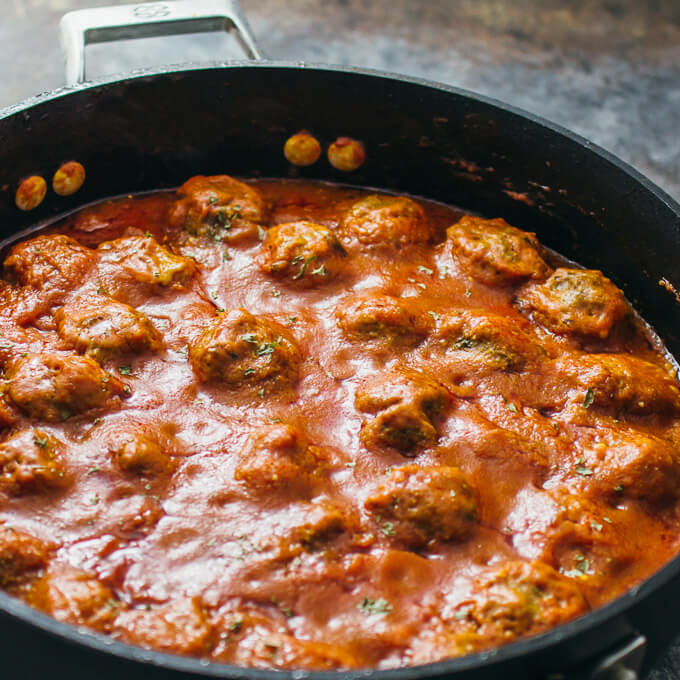 Meatballs cooking in mexican chipotle sauce in a nonstick pan