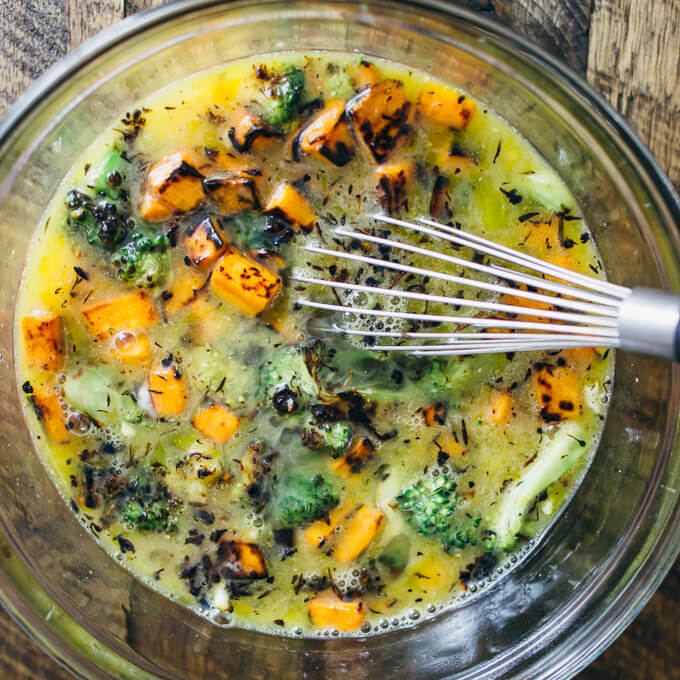 Stirring eggs with cooked sweet potatoes and broccoli
