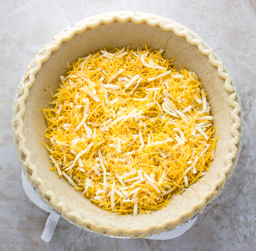 adding cheese for a quiche