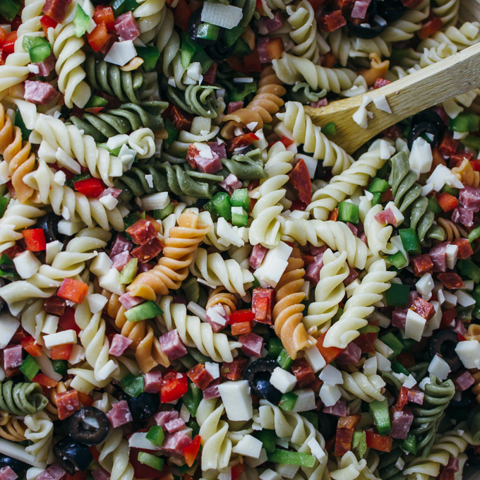 stirring pasta salad ingredients together