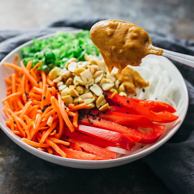 adding peanut butter dressing to salad ingredients