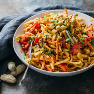 peanut noodle salad served in white bowl