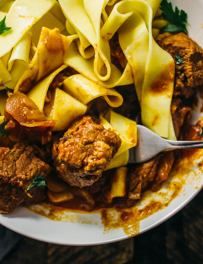 stirring hungarian beef goulash with noodles