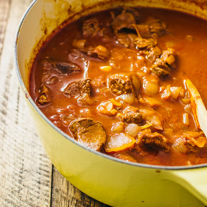 stirring hungarian beef goulash in a pot