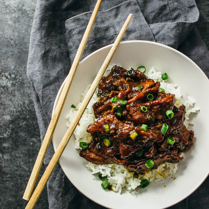 mongolian beef served with white rice in a bowl