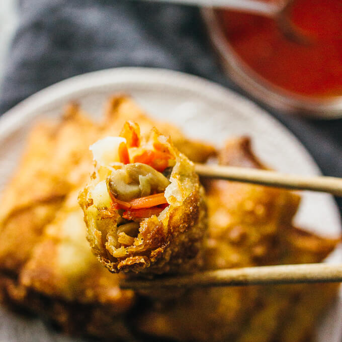 vegetable egg roll held up with chopsticks