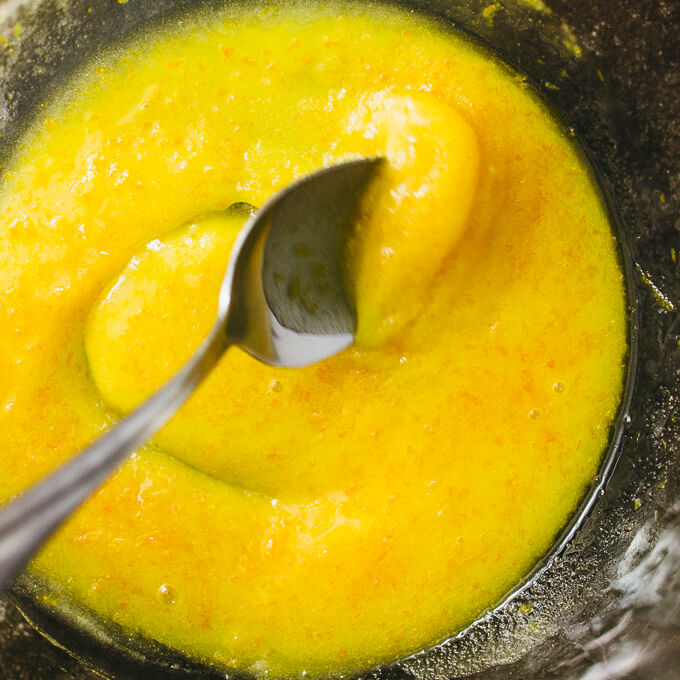 stirring orange glaze in a bowl