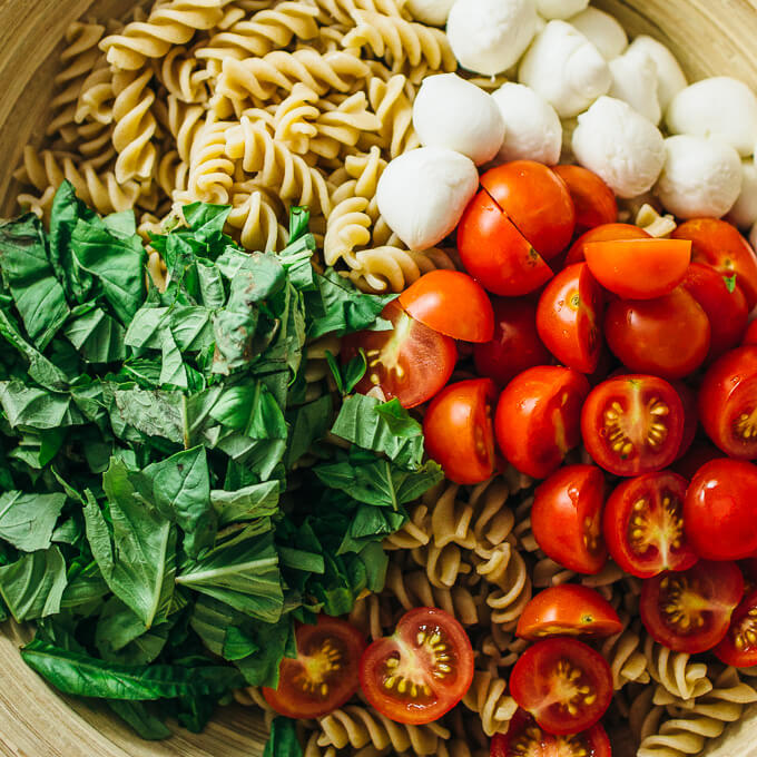 Easy caprese pasta salad with cherry tomatoes, mozzarella, and basil
