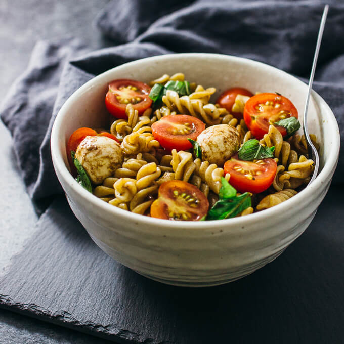 Easy caprese pasta salad with cherry tomatoes, mozzarella, and basil
