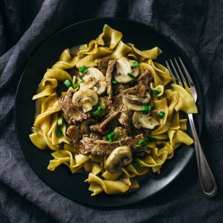 beef stroganoff served on a black plate