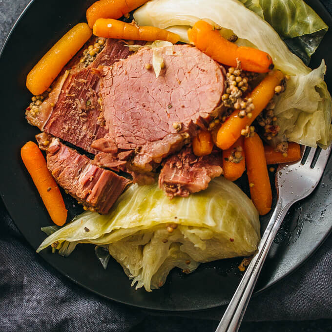 Overhead view of corned beef dinner on black plate