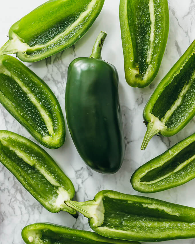 slicing each jalapeno in half lengthwise
