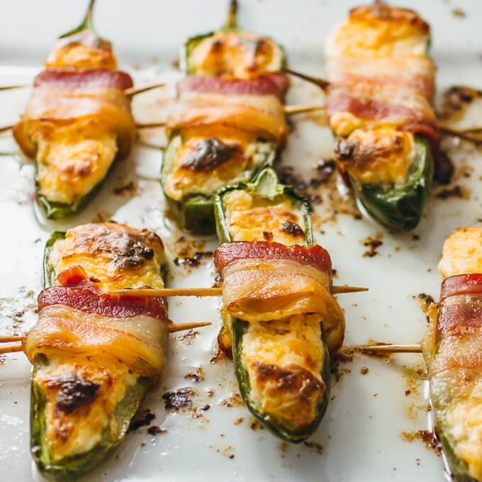 Bacon wrapped jalapeño peppers on white baking dish