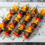 hawaiian steak kabobs served on white platter