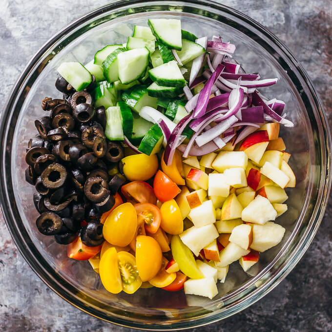 greek salad ingredients in glass bowl