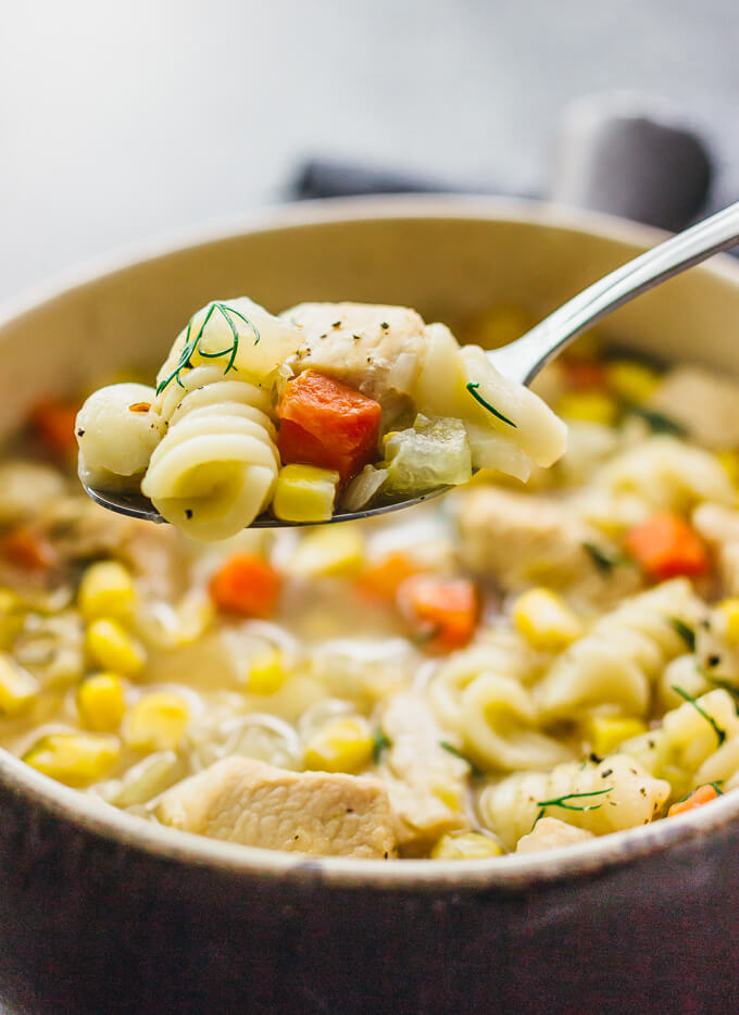 lifting up chicken noodle soup in a spoon