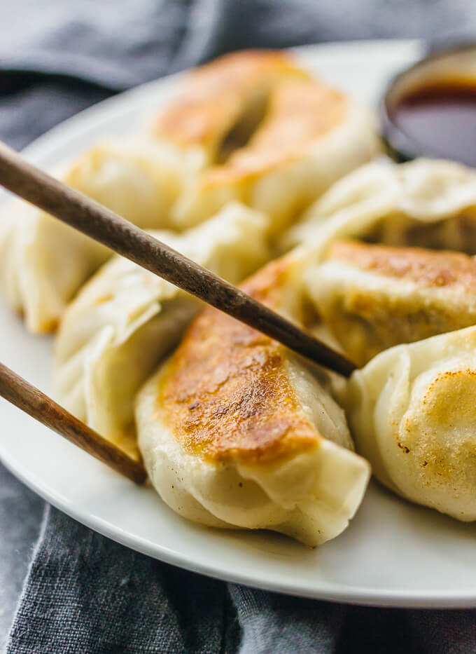 chopsticks picking up a fried potsticker