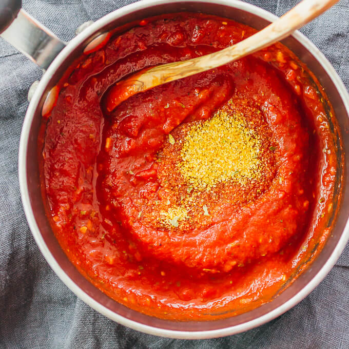 stirring seasonings into pizza sauce