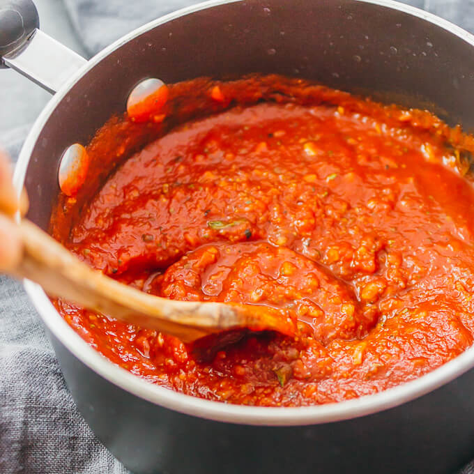 stirring pizza sauce in saucepan