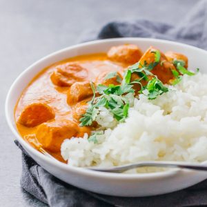 potato curry served with rice in white bowl