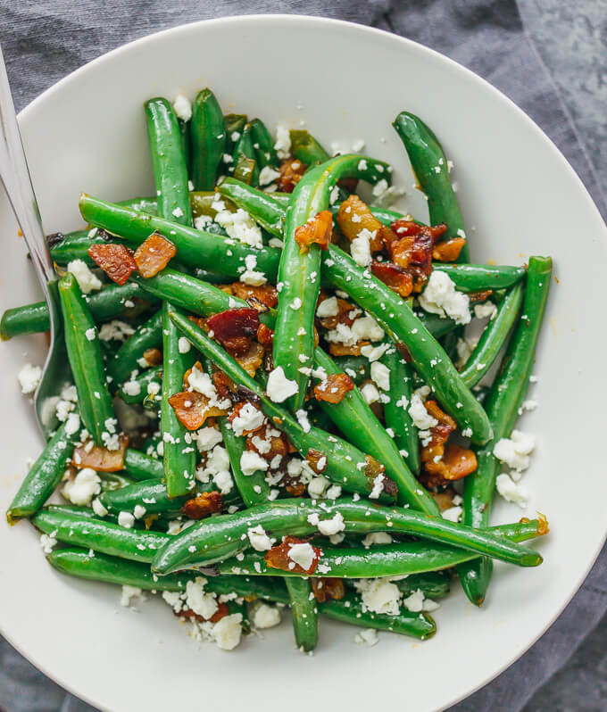 Learn how to cook garlic green beans sauteed with crispy diced bacon and crumbled feta cheese.