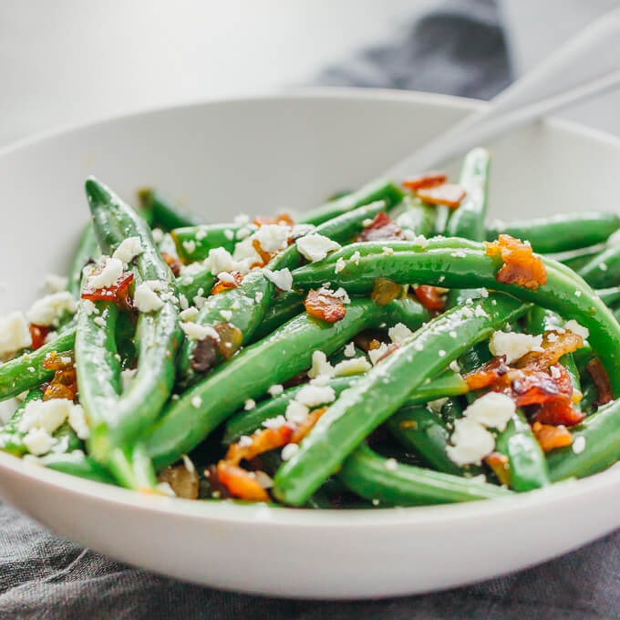 Learn how to cook garlic green beans sauteed with crispy diced bacon and crumbled feta cheese.