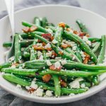 Learn how to cook garlic green beans sauteed with crispy diced bacon and crumbled feta cheese.