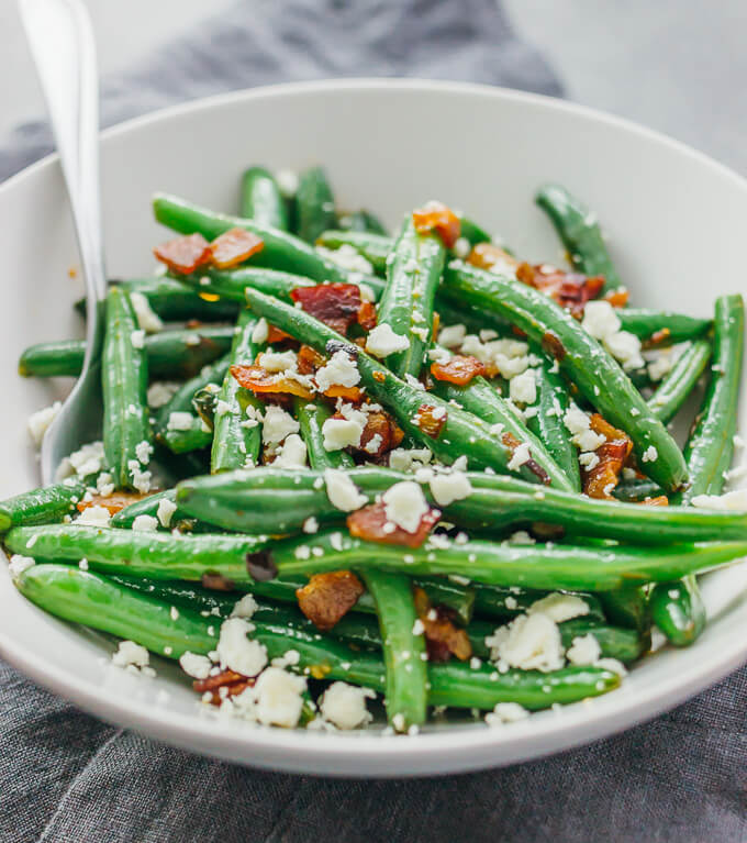 Learn how to cook garlic green beans sauteed with crispy diced bacon and crumbled feta cheese.