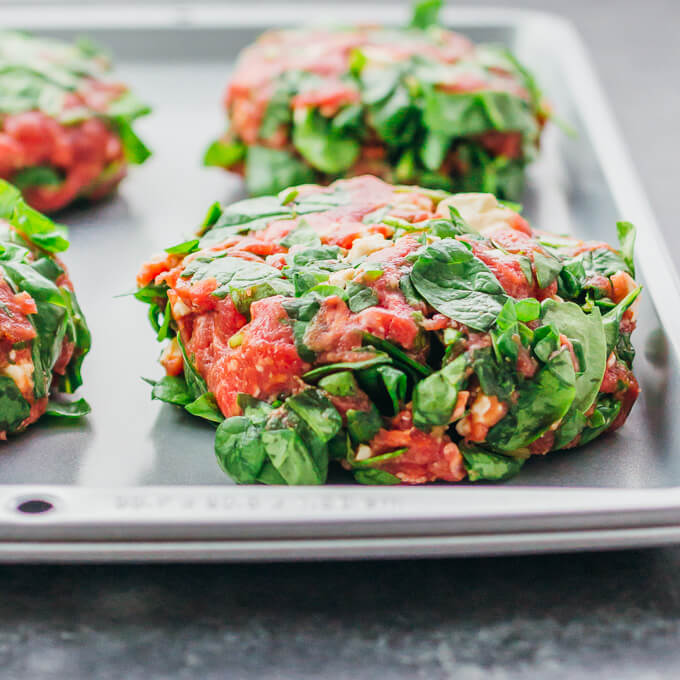 These Greek burgers are made using ground beef mixed with spinach, feta, and sun-dried tomatoes, plus drizzled with a delicious tzatziki sauce.