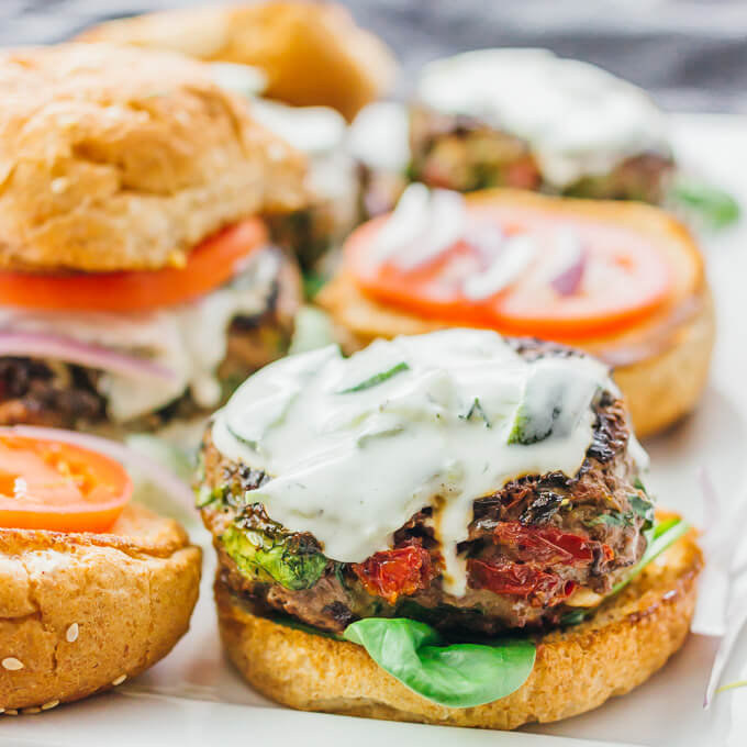 adding toppings and buns to a greek burger