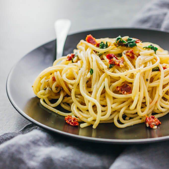 spaghetti aglio e olio served on a black plate