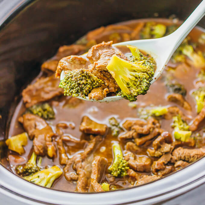 lifting up beef and broccoli from a slow cooker