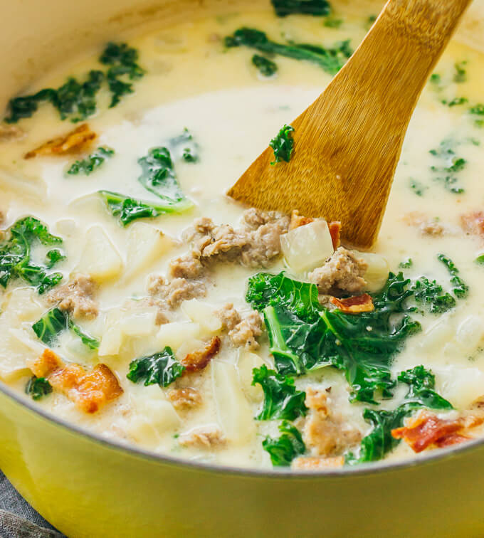 stirring zuppa toscana in a dutch oven