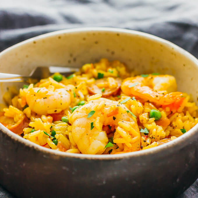 This is my everyday paella: an easy one pot meal with shrimp, smoked sausage, tomatoes, onions, peas, garlic, and saffron.