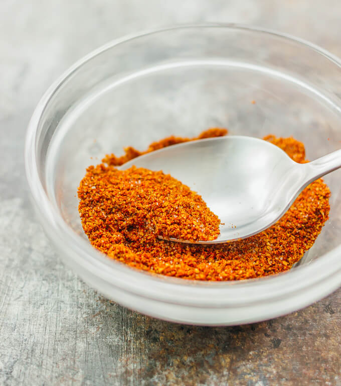 Mixture of spices like cayenne, paprika, cumin, and garlic powder in a glass bowl