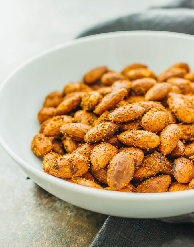 Savory spiced almonds served in a white bowl for a healthy and flavorful snack.