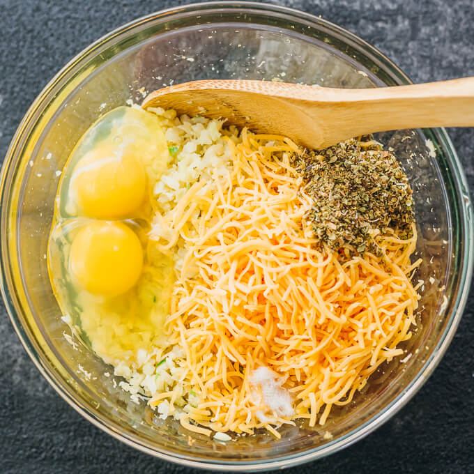 Make this healthy, low carb flatbread recipe using riced cauliflower. It's topped with pesto sauce and grated parmesan cheese.