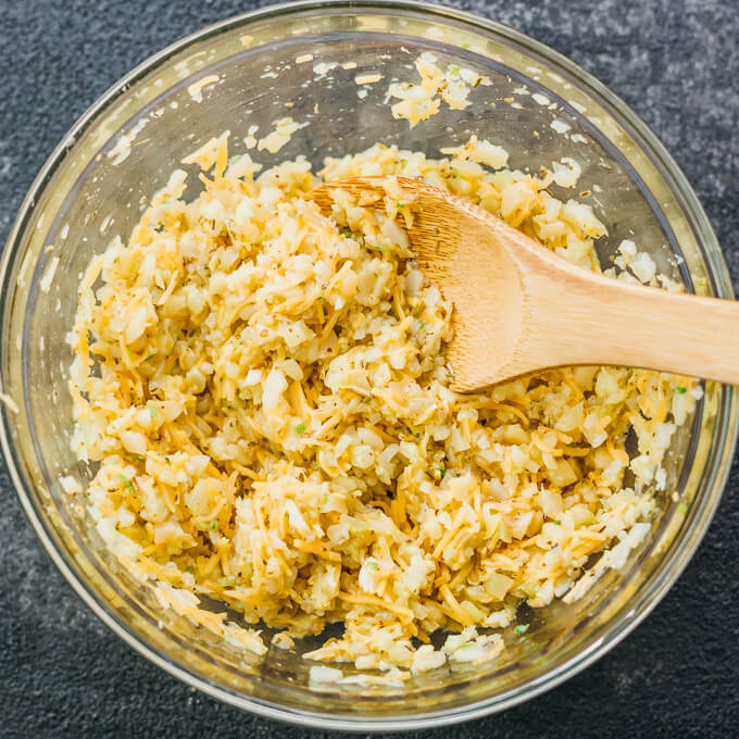 Make this healthy, low carb flatbread recipe using riced cauliflower. It's topped with pesto sauce and grated parmesan cheese.