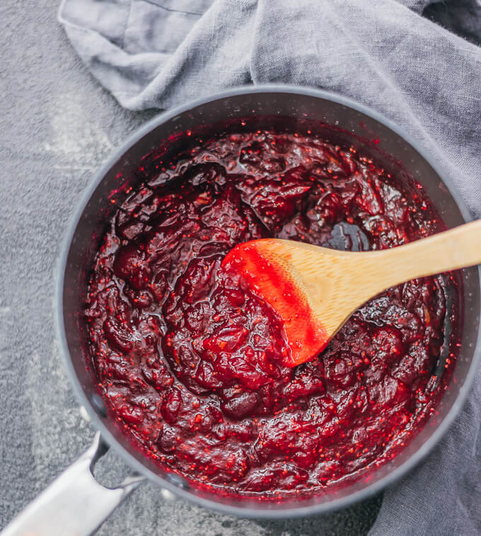 stirring cranberry sauce in saucepan