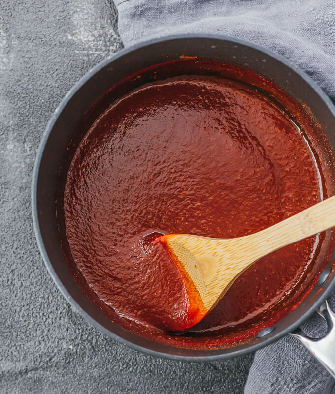 bbq sauce cooked in saucepan with wooden spoon