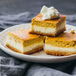 pumpkin cheesecake bars served on white plate