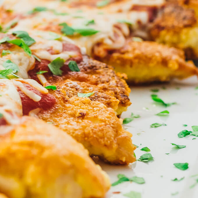 These healthy and low carb chicken parmesan tenders are fried in a pan on the stovetop and broiled in the oven to melt mozzarella cheese