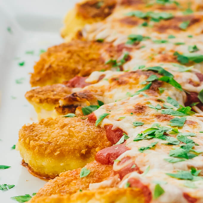 Easy chicken parmesan tenders fried on a pan and baked until crispy with tomato sauce and mozzarella cheese