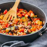 Making eggplant caponata recipe in a pan on the stovetop