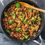 Low carb, keto friendly beef and broccoli recipe in an overhead pan shot with wooden spoon