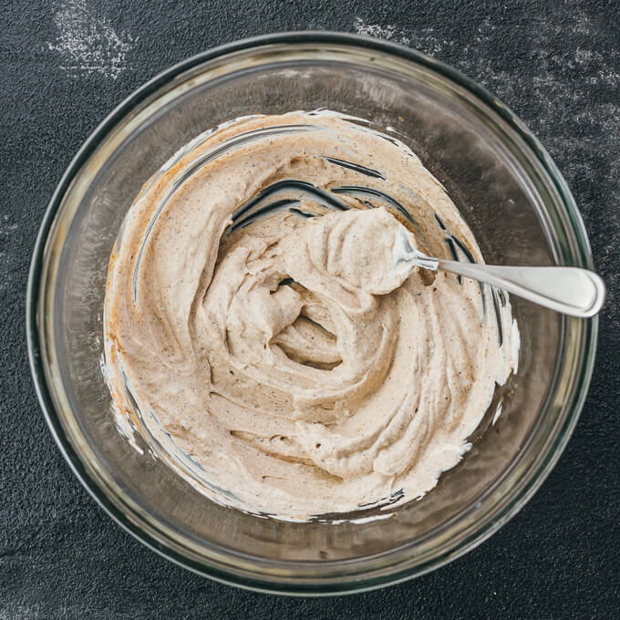 stirring yogurt marinade in glass bowl